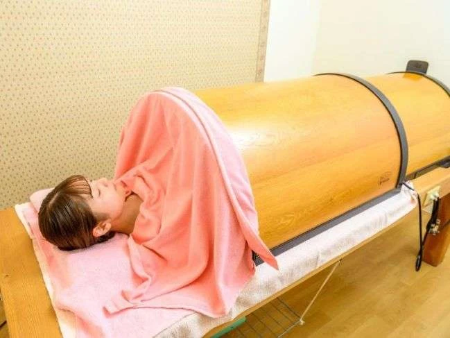 琉球温熱ドームベッドに入ってリラックスしながら汗をかいているお客様